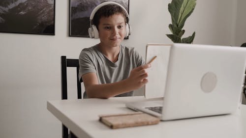A Boy Showing His School Work Through Video Call