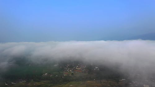 Aerial Shot of a Town Covered with Fog