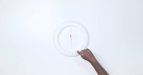 Man Moving Hands of Wall Clock
