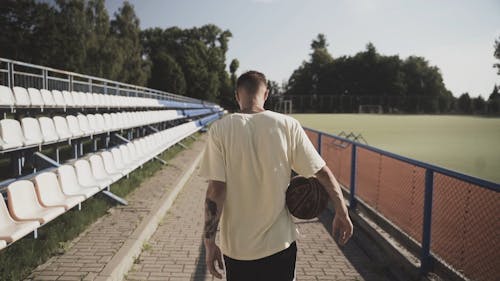 A Man Walking With A Basketball