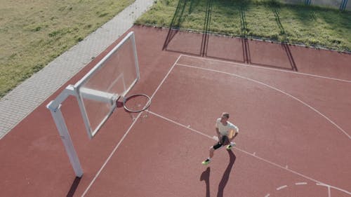 A Basketball Player Shooting The Ball In A Reverse Layup