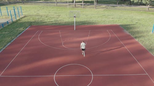 A Man Playing Basketball In A Court