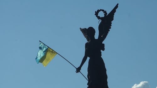 A Statue Holding The Flag Of Ukraine