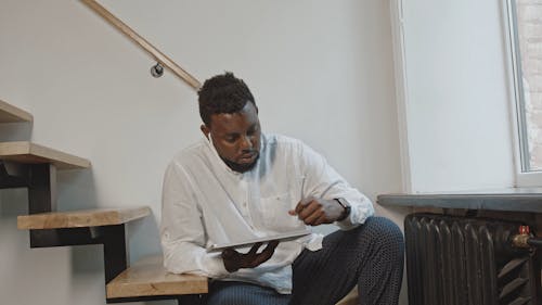 A Man Using Stylus Pen On A Tablet