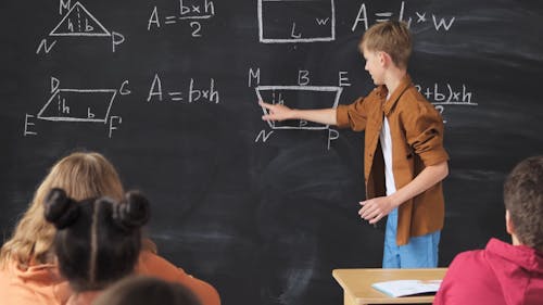 A  Student Solving A Math Equation On The Blackboard