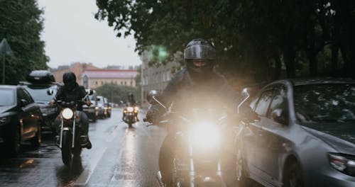 People Riding a Motorcycles on a Rainy Day