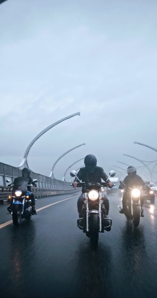 Group Of Riders Riding On Wet Roads On A Rainy Day