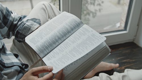 Close-Up View of a Person Reading a Bible