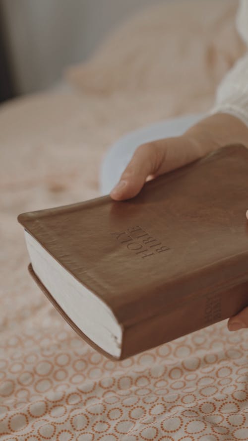 Close-Up View of a Person Opening a Bible