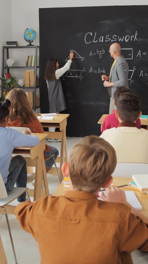 A Student Solving A Math Equation In The Blackboard