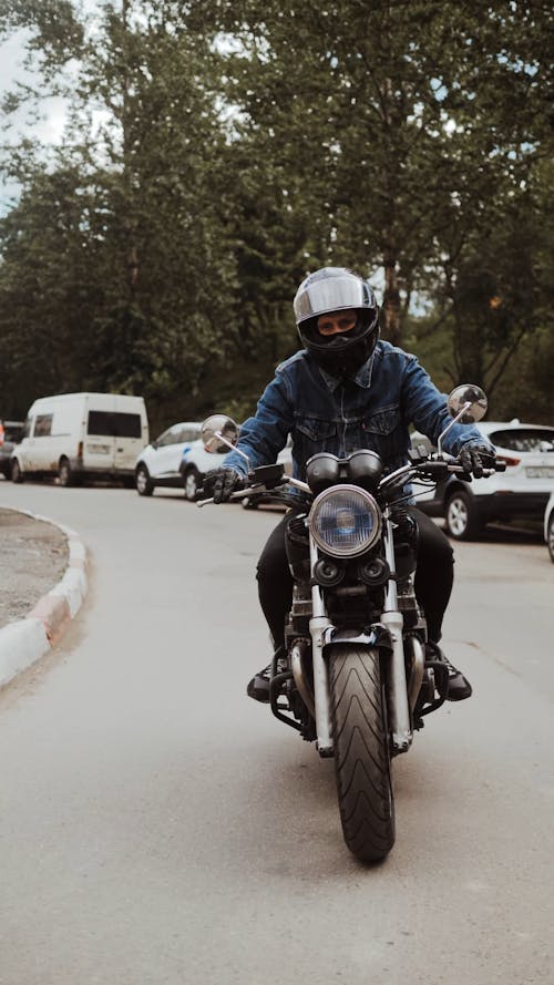 Man in Blue Denim Jacket Driving His Motorcycle