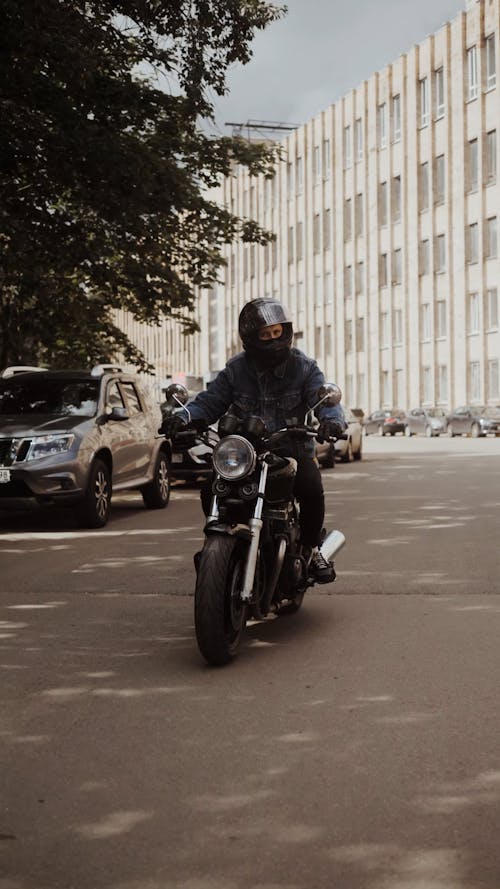 Man in Blue Denim Jacket Driving His Motorbike