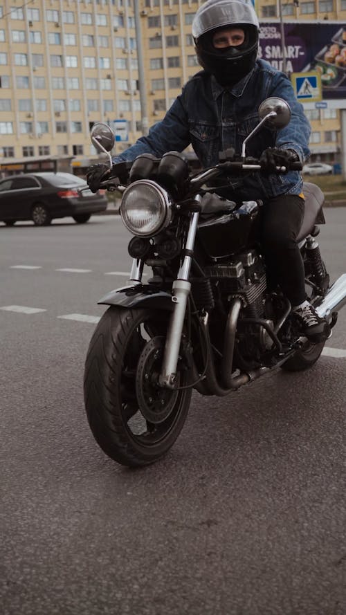 Man in Blue Denim Jacket Driving His Motorcycle on Road