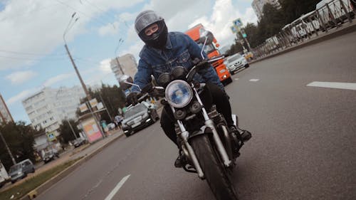 Man in Blue Denim Jacket Driving His Motorcycle