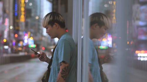 Man with Colored Hair Using a Cellphone