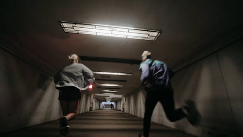 Back View of a Group of Friends Running in a Tunnel