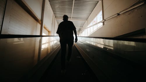 Man Walking at an Escalator of Abandoned Building