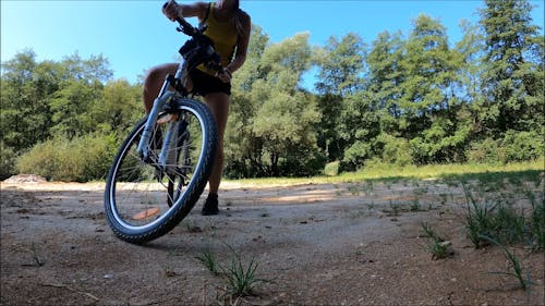 Woman Rides a Bicycle away in the woods