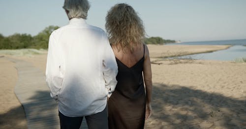 A Couple Walking on a Wooden Walkway