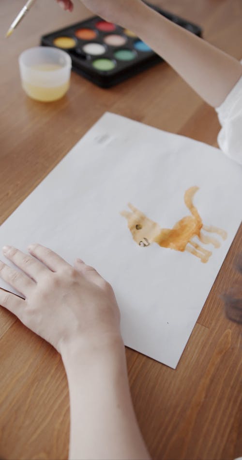 Person Using Watercolor for Painting in the White Paper