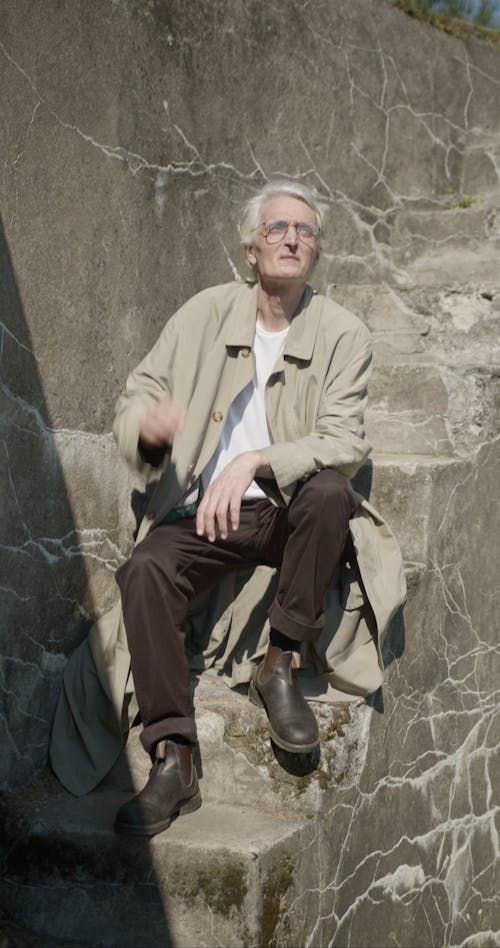 Elderly Man Sitting on Stairs