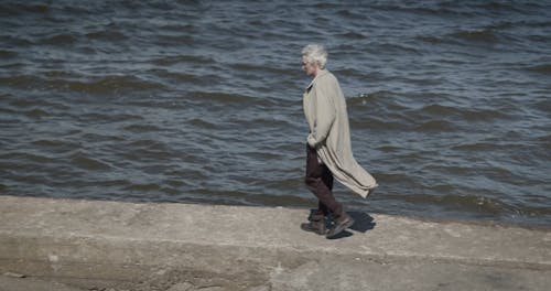 An Elderly Man Walking by the Sea