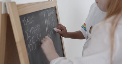 Kids Solving Math Problems on a Board