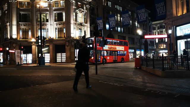 Oxford Circus at night, with red buses and city lights.