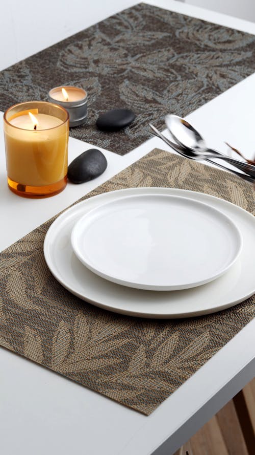 A Person Placing Cutlery on a White Plate 