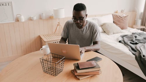 High Angle View of a Man Working on Laptop and Drinks Coffee