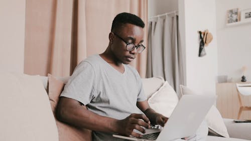 Low Angle Shot of a Man Busy Working on Laptop