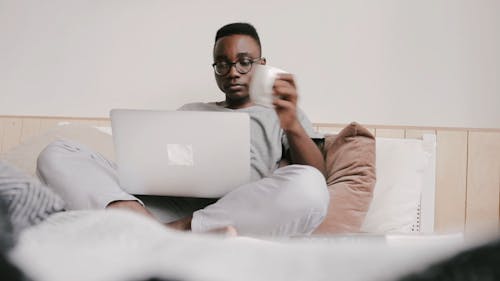 Man Using His Laptop On Bed
