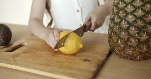 Person Slicing the Lemon