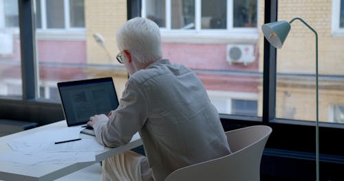A Man Typing on His Laptop