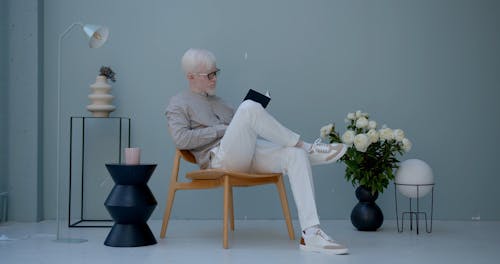 A Man Reading His Journal While Drinking Coffee