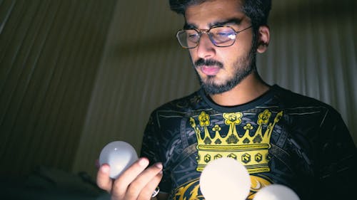 A Man Holding Three Light Bulbs