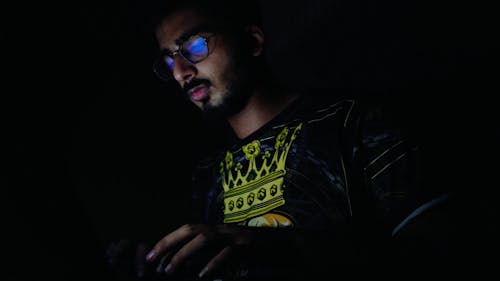 A Man Typing in the Dark