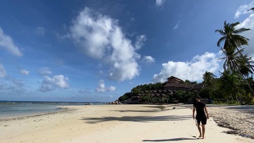 A Man Walking Barefooted In The Beach Shore