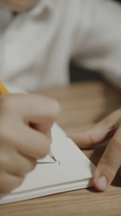 A Student Writing A Mathematical Equation On A Notebook