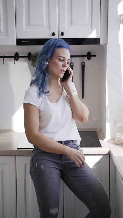 A Woman Talking on the Phone in the Kitchen