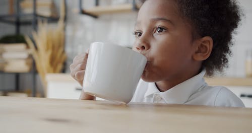 A Boy Taking Drinking from a Coffee Cup