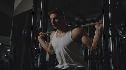 Side View of a Man Doing Barbell Squats 