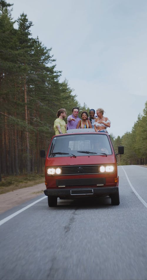 A Moving Truck Loaded with Happy Group of Friends on Road Trip