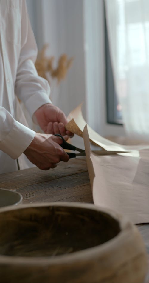 People Cutting a Sheet of Paper