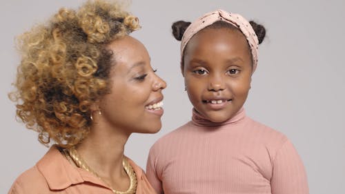 Woman Kissing Her Daughter On The Cheek