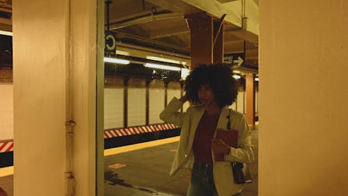 Young Woman Looking in Mirror Fixing her Hair