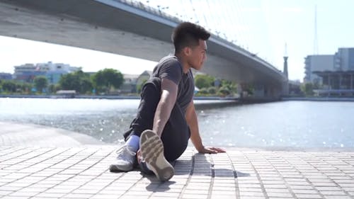 Young Man Sitting Stretching Legs