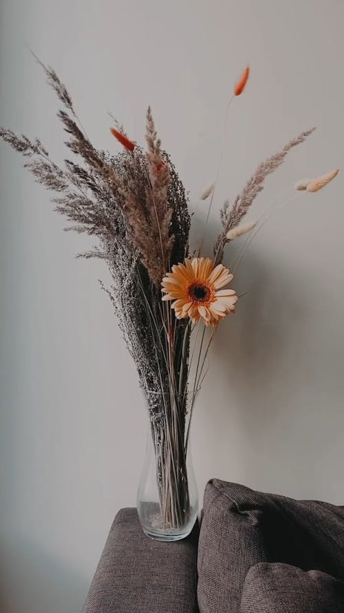 A Flower and Ornamental Grass on a Glass Vase