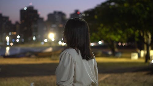 Shallow Focus of Woman in White Top Standing Outdoors