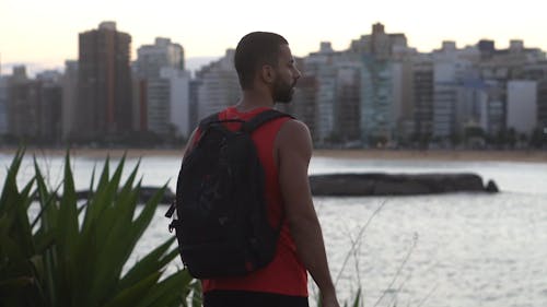 Shallow Focus of Man With Backpack Standing Outdoors